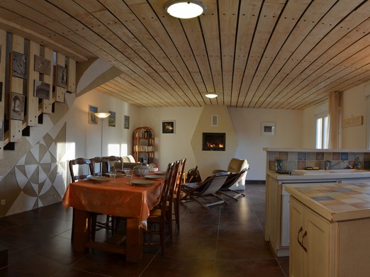 Grande pièce de vie avec cuisine, séjour et salon. Poêle à bois.