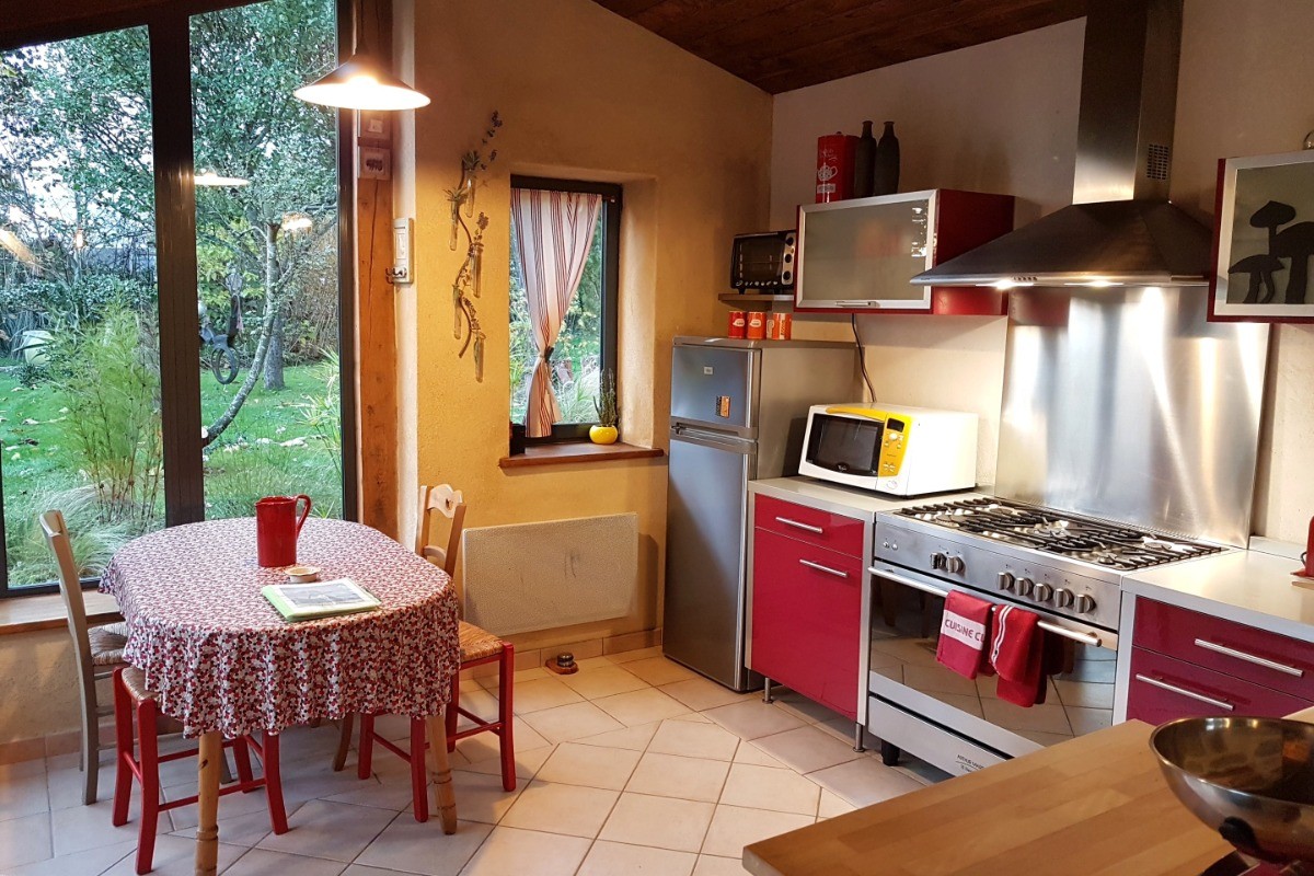 Jolie cuisine indépendante et lumineuse dans la véranda. Parfaitement équipée. Table repas en plus du séjour.