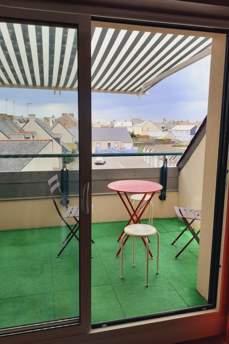Balcon avec salon de jardin et store banne.