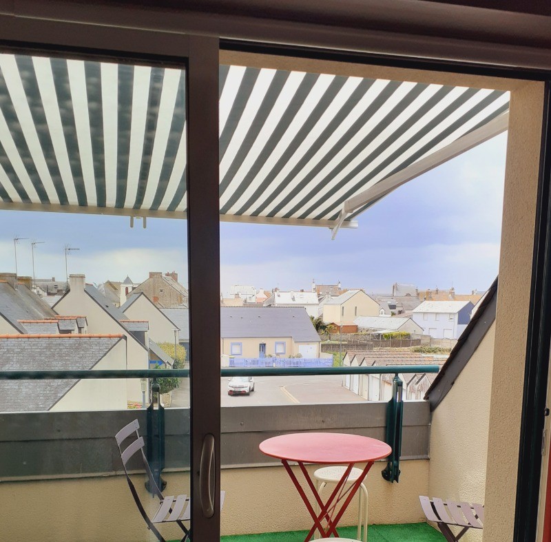 Balcon avec salon de jardin et store banne.