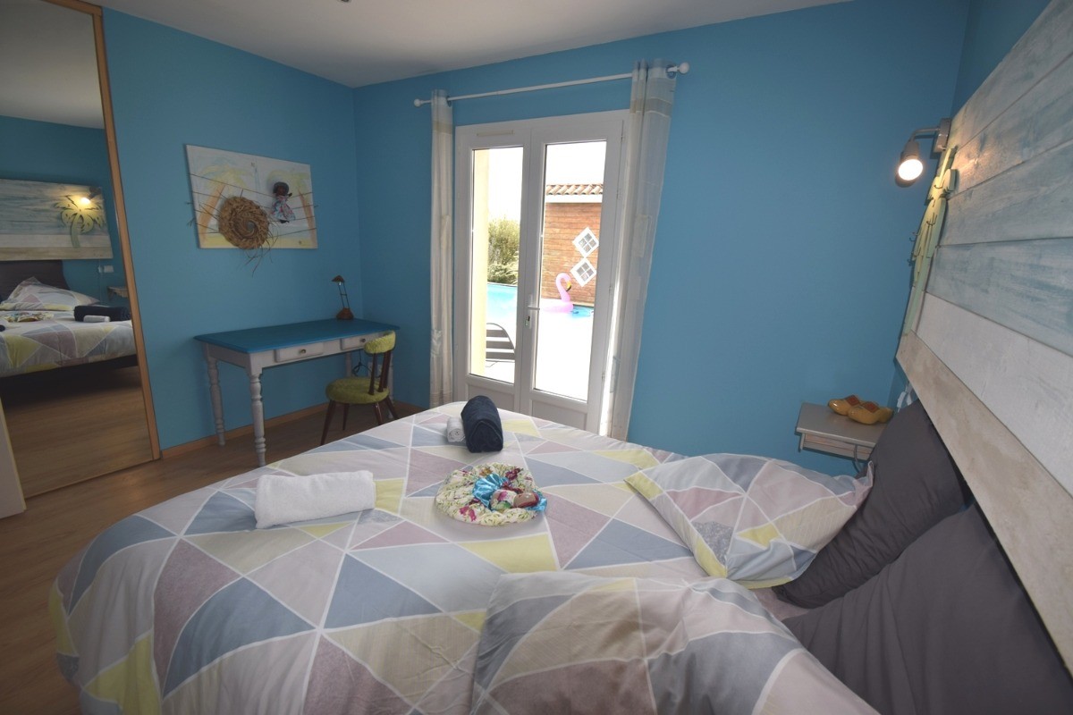 La chambre 3 avec son lit ferme en 160. Vue sur la piscine
