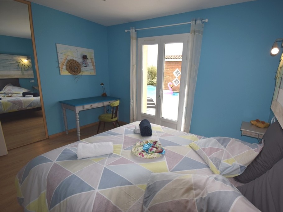 La chambre 3 avec son lit ferme en 160. Vue sur la piscine