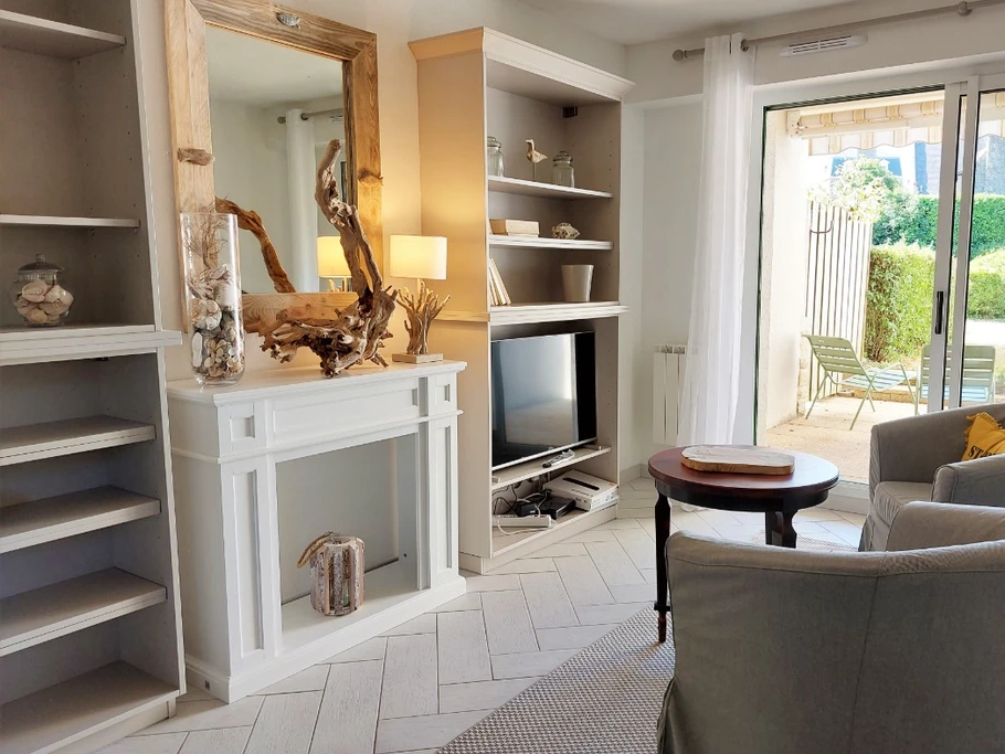 Salon avec TV dans une pièce de vie lumineuse en rez-de-jardin. Terrasse ombragée en accès direct.
Crédits photo : Yannick Goulvestre