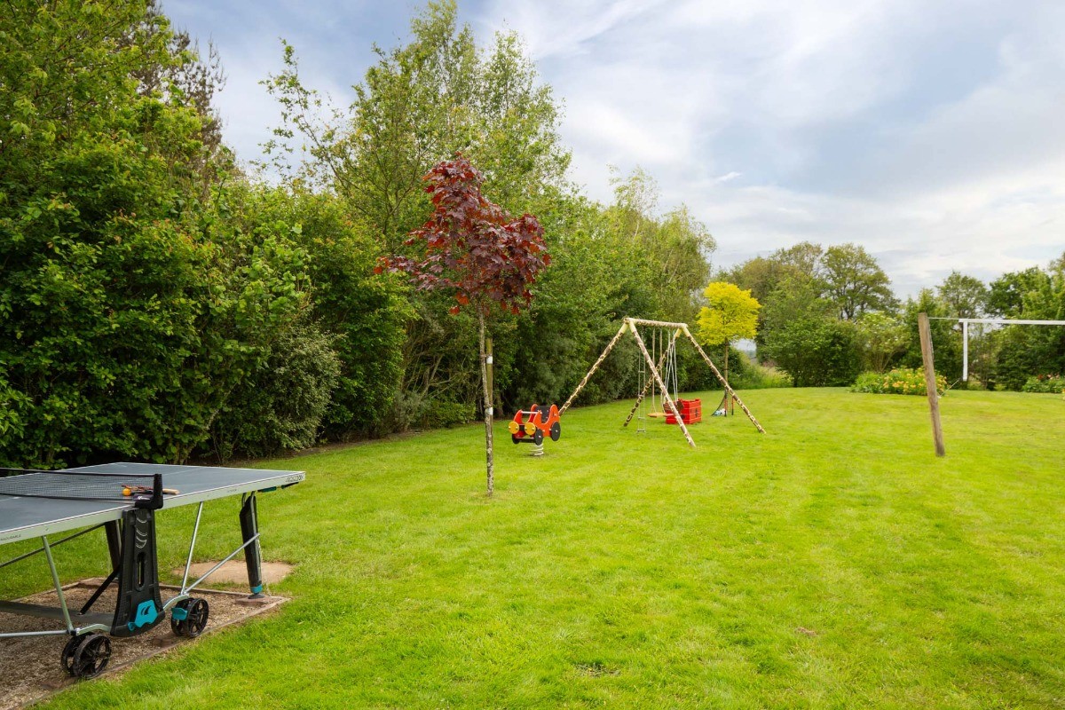 Parc de loisirs avec jeu sur ressort, balançoire, table de ping pong, terrain de volley, terrain de pétanque. Ballons, frisbees, boules de pétanque, raquettes et balles à disposition.
