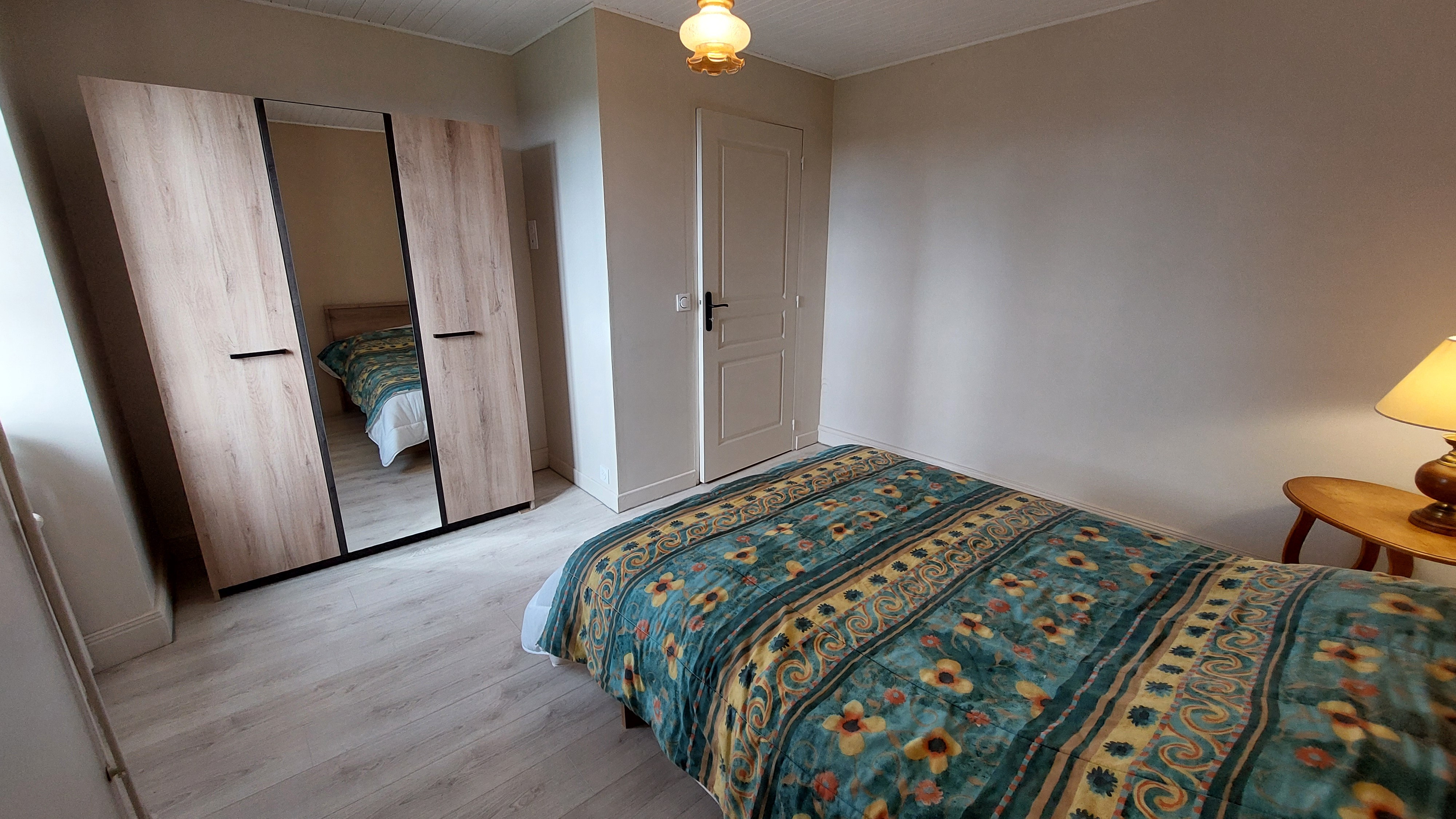 Bedroom with double bed and mirrored wardrobe in family gîte
