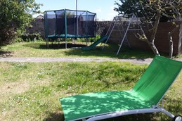 Grand jardin clos et arboré à l'arrière de la maison, à l'abris du vent. Bien équipé pour la détente : salon de jardin pour 15 personnes, barbecues, transats toboggan, trampoline, balançoire...