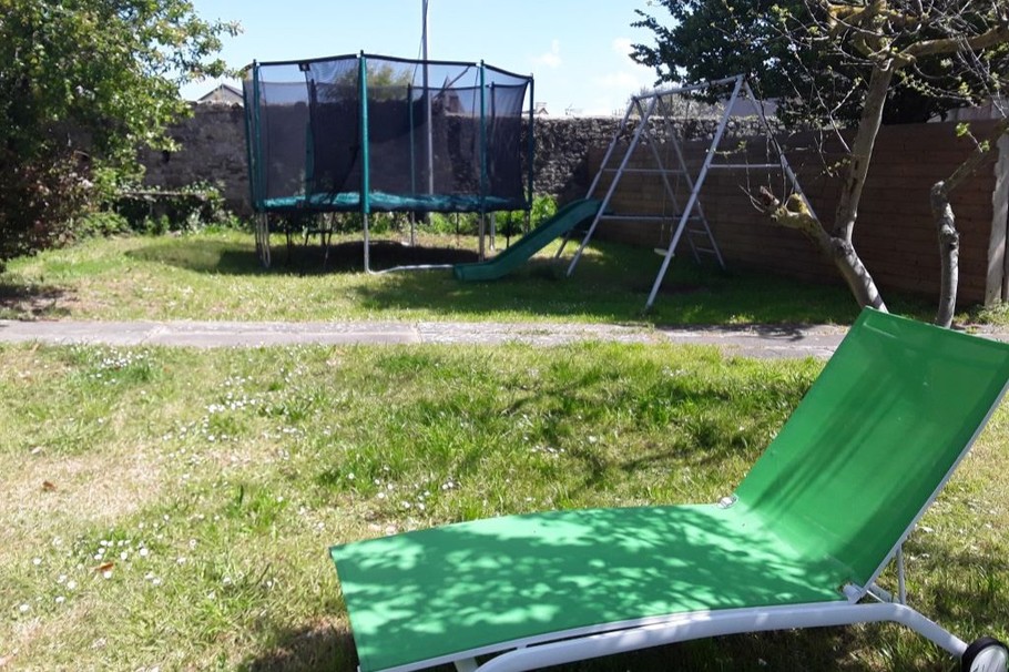 Grand jardin clos et arboré à l'arrière de la maison, à l'abris du vent. Bien équipé pour la détente : salon de jardin pour 15 personnes, barbecues, transats toboggan, trampoline, balançoire...
