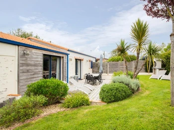 Jardin privatif avec terrasse, salon de jardin, transats, parasol, barbecue et fils à linge.