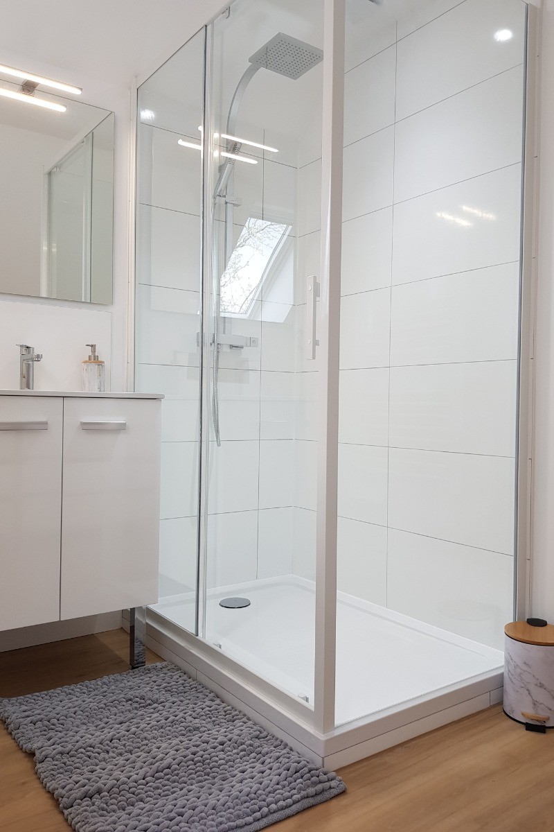 Salle d'eau avec meuble vasque et douche grande dimension à l'étage dans la chambre indépendante.
