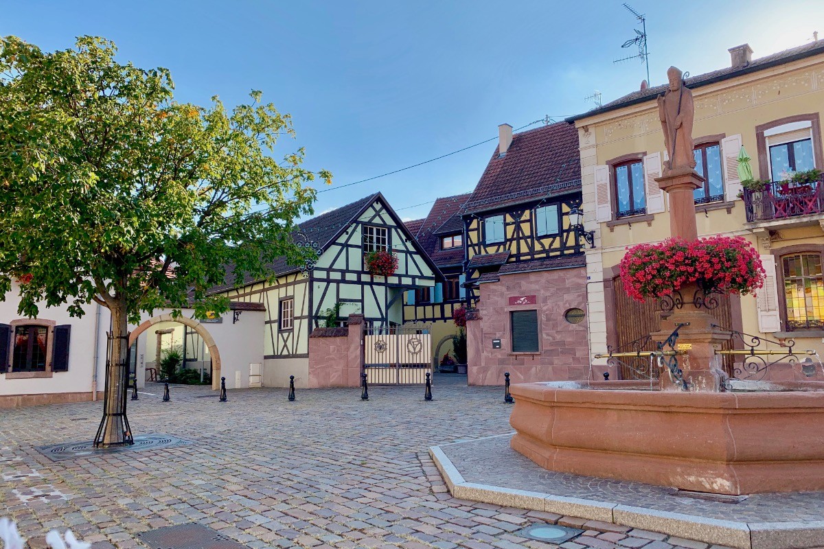 Vous êtes arrivés "Au Vigneron Heureux" , il se trouve dans la maison jaune à colombages, partie de gauche