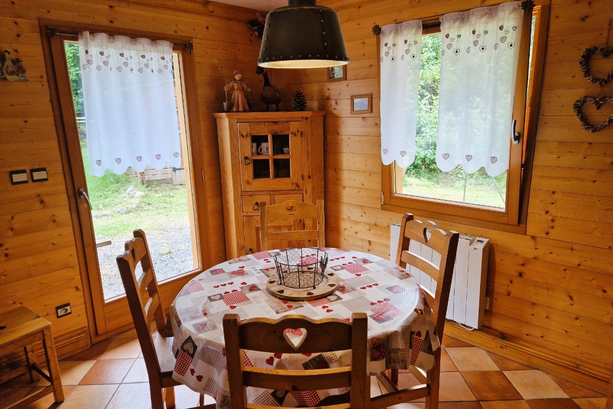 Pièce de vie avec une table ronde, ouverture sur la terrasse extérieure - Chalet Biazot, proche du Lac de Xonrupt-Longemer