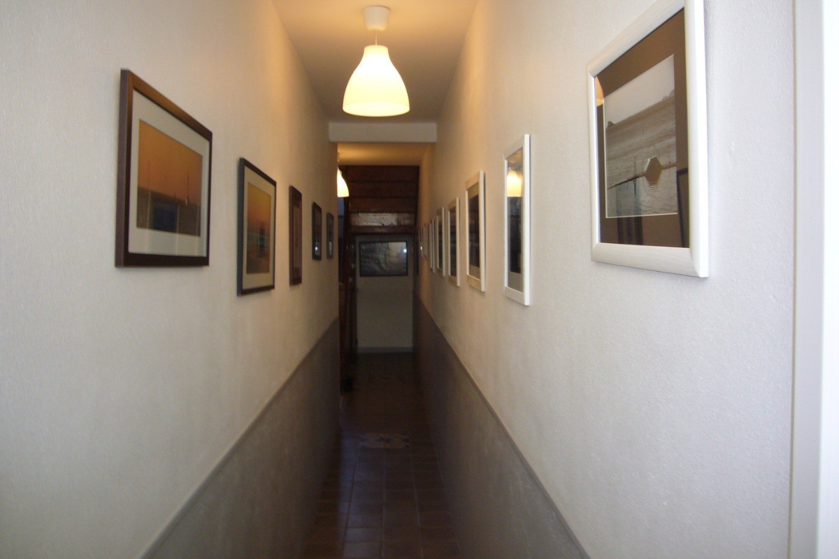 Couloir avec de magnifiques photographies de la région. Il conduit au garage et à la terrasse.