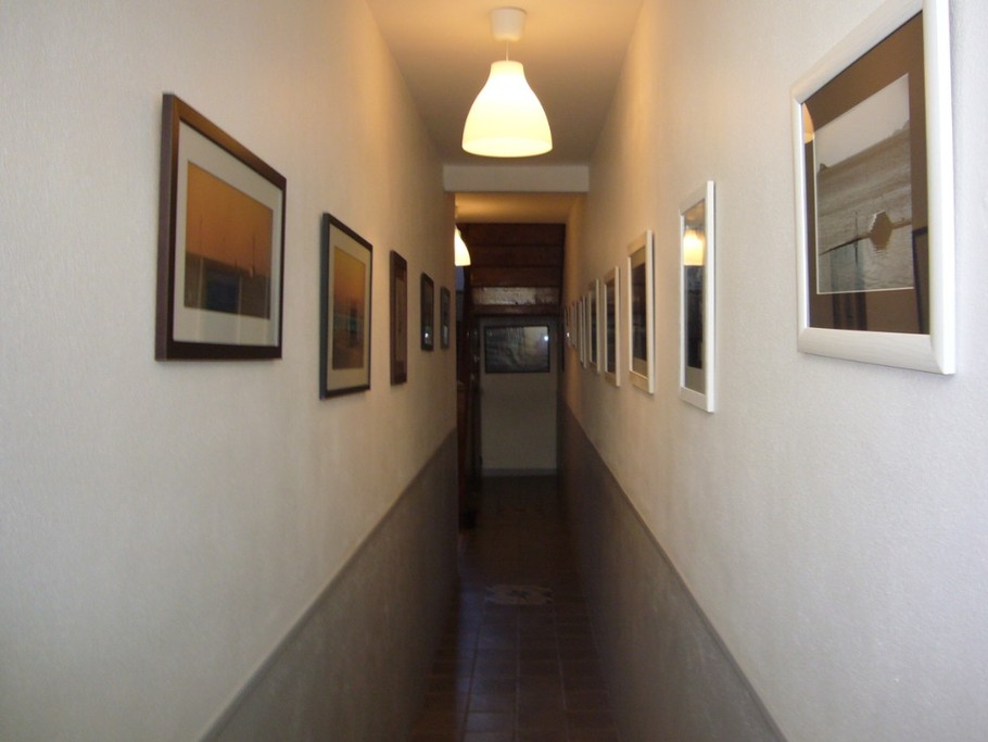 Couloir avec de magnifiques photographies de la région. Il conduit au garage et à la terrasse.