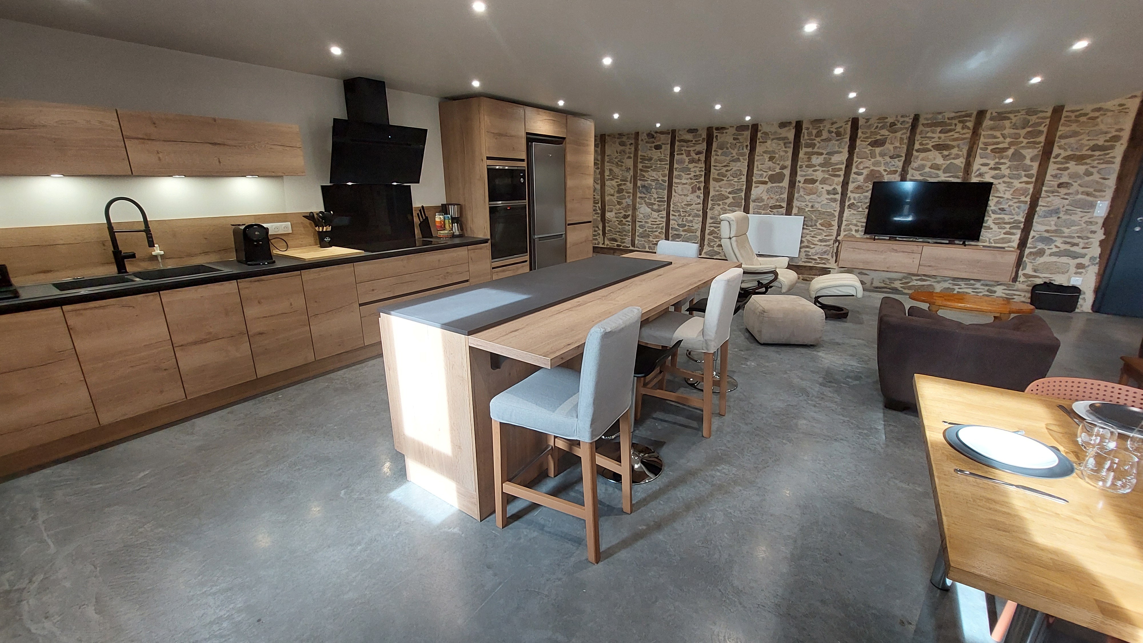 Cuisine moderne du gîte avec îlot central et plan bar, idéale pour cuisiner et partager des moments conviviaux