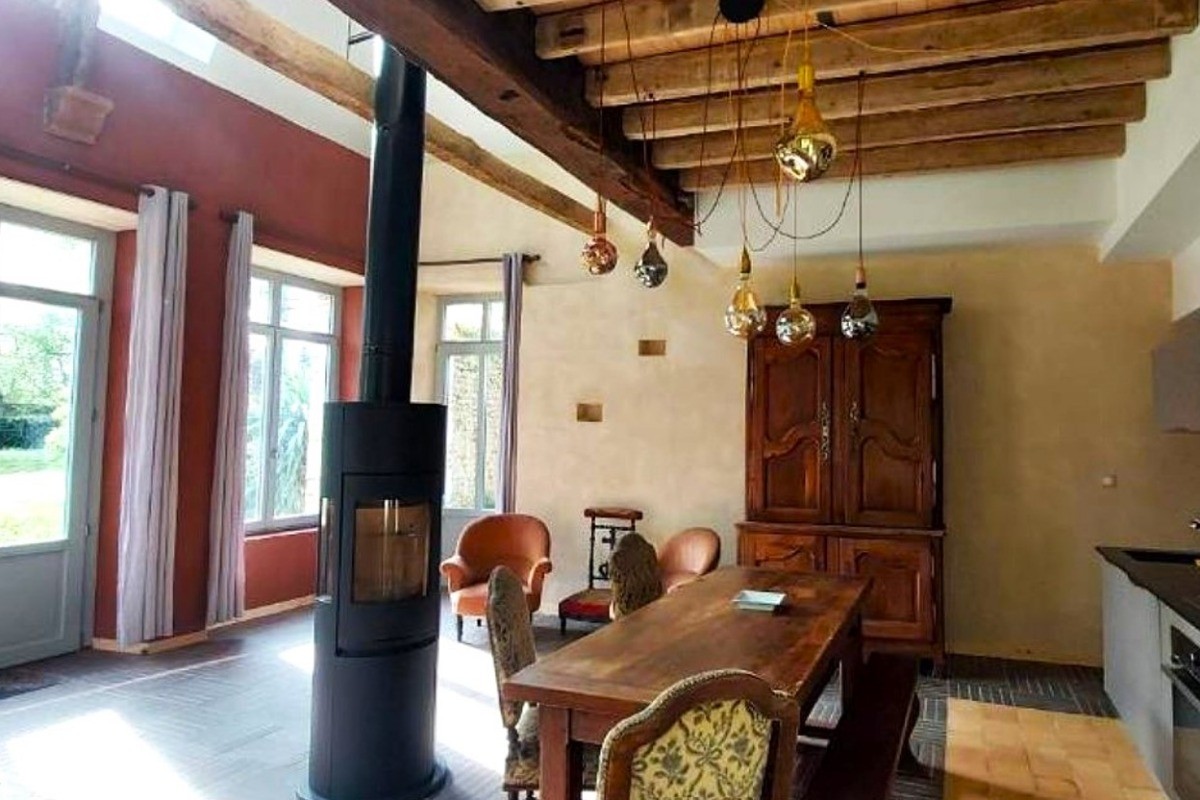 Pièce de vie en rez-de-jardin équipée d'un poêle à bois, avec espace salon, espace séjour et espace cuisine parfaitement équipée. Vaisselle haut de gamme fabriquée en France et électroménager de très bonne qualité.