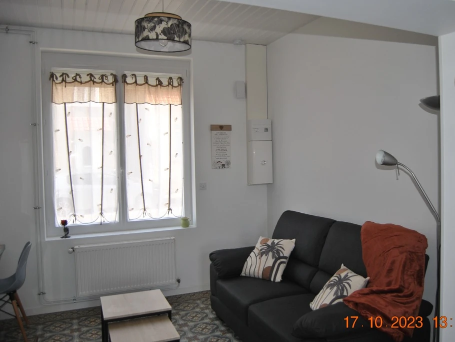 Salon avec son canapé confortable,  un plaid et deux coussins. Équipe d'un détecteur de fumée pour votre sécurité.(Appartement L'entre 2 Caps)