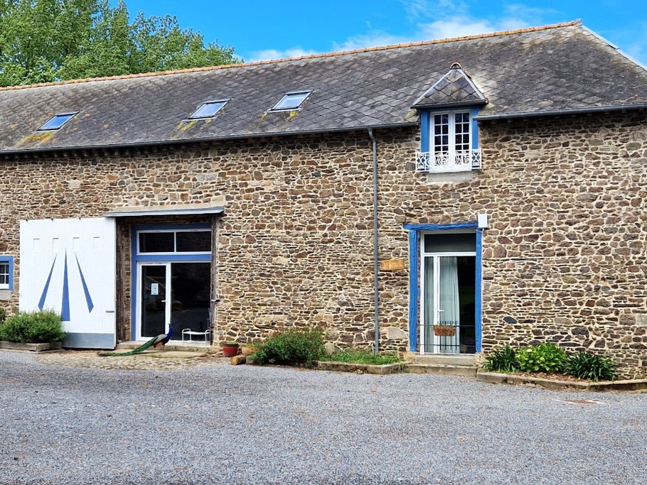 La façade du gîte, une maison en pierres de pays. L'entrée se situe à l'arrière. A gauche de la photo, le local piscine intérieure, commune à une autre gîte.