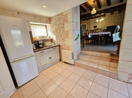 La cuisine aménagée avec le séjour et la cheminée au fond de la pièce