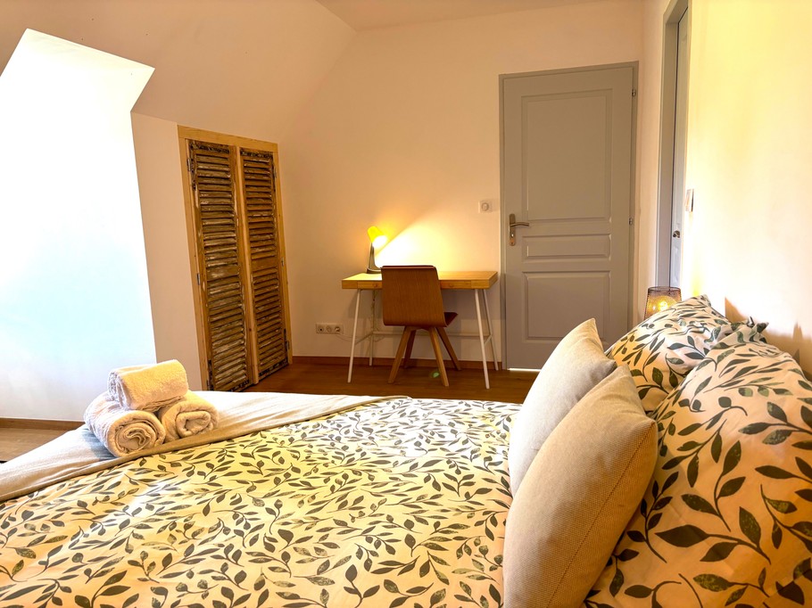 Chambre 2 à l'étage avec lit 160 cm, bureau et rangements. Salle d'eau communicante avec douche grande dimension et WC.