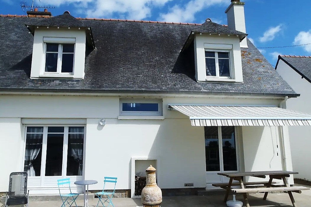 Façade arrière de la maison avec terrasse, salon de jardin, transat, brasero