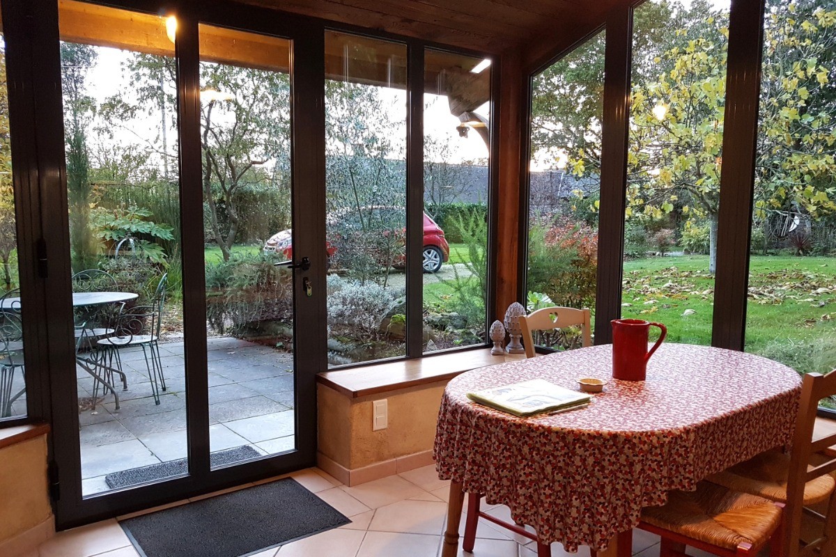 Vue sur la terrasse et le jardin depuis la table de la cuisine.