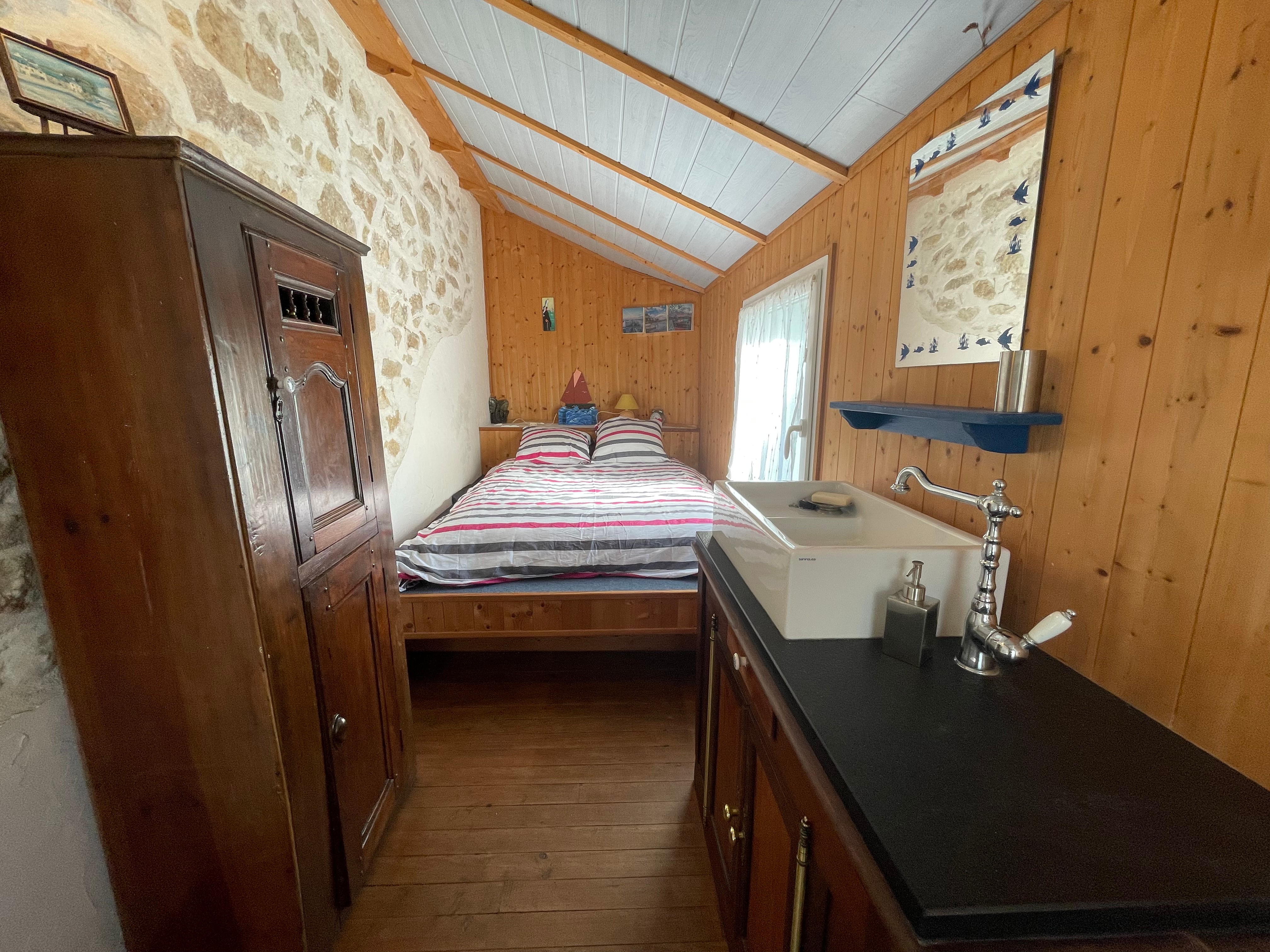 On a half landing is a bedroom with a double bed (140cm) and a washbasin.