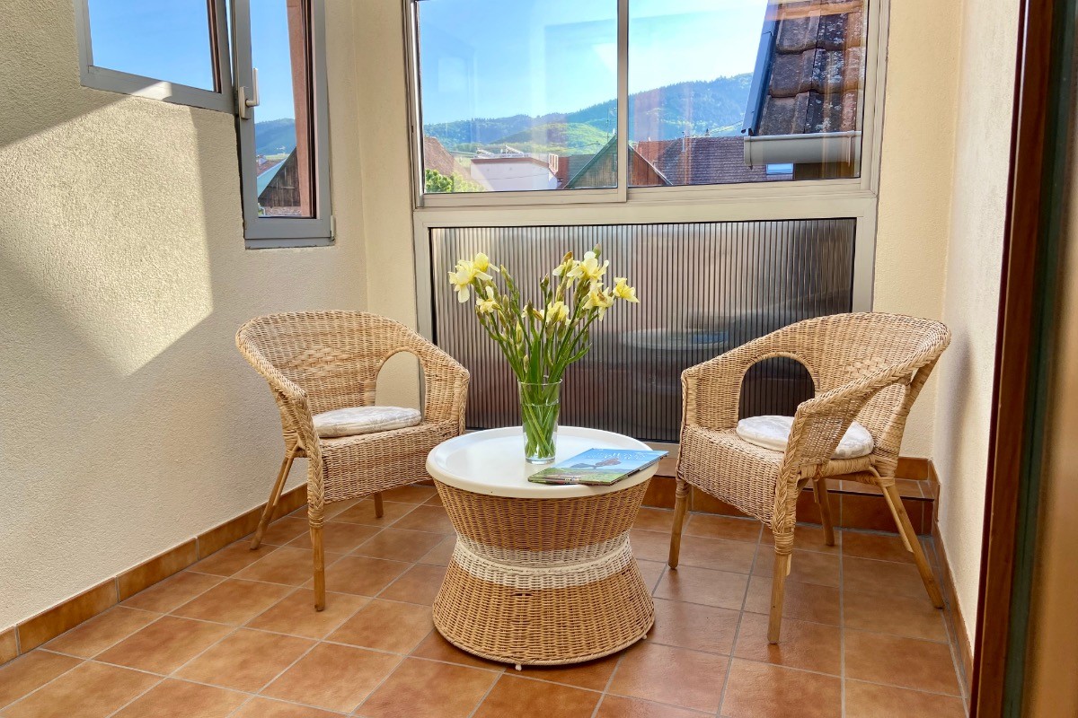Loggia à l'étage avec vue sur les toits et en arrière plan vignes et châteaux