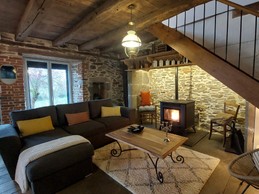 Salon chaleureux avec poêle à bois et canapé confortable