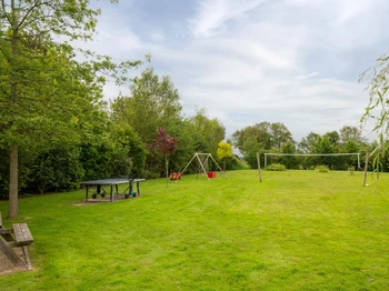 Parc de loisirs avec jeu sur ressort, balançoire, table de ping pong, terrain de volley, terrain de pétanque. Ballons, frisbees, boules de pétanque, raquettes et balles à disposition.