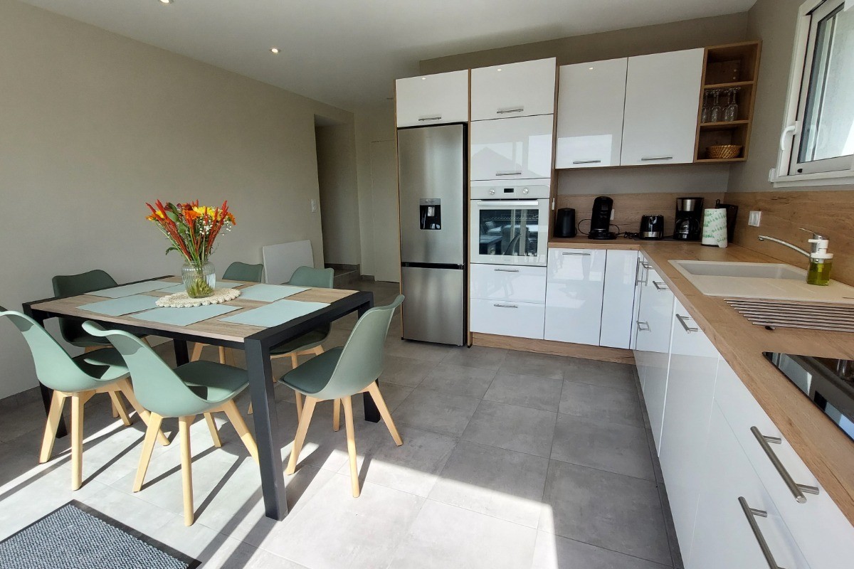 Cuisine équipée et lumineuse avec accès direct à la terrasse, parfaite pour préparer de bons petits plats."