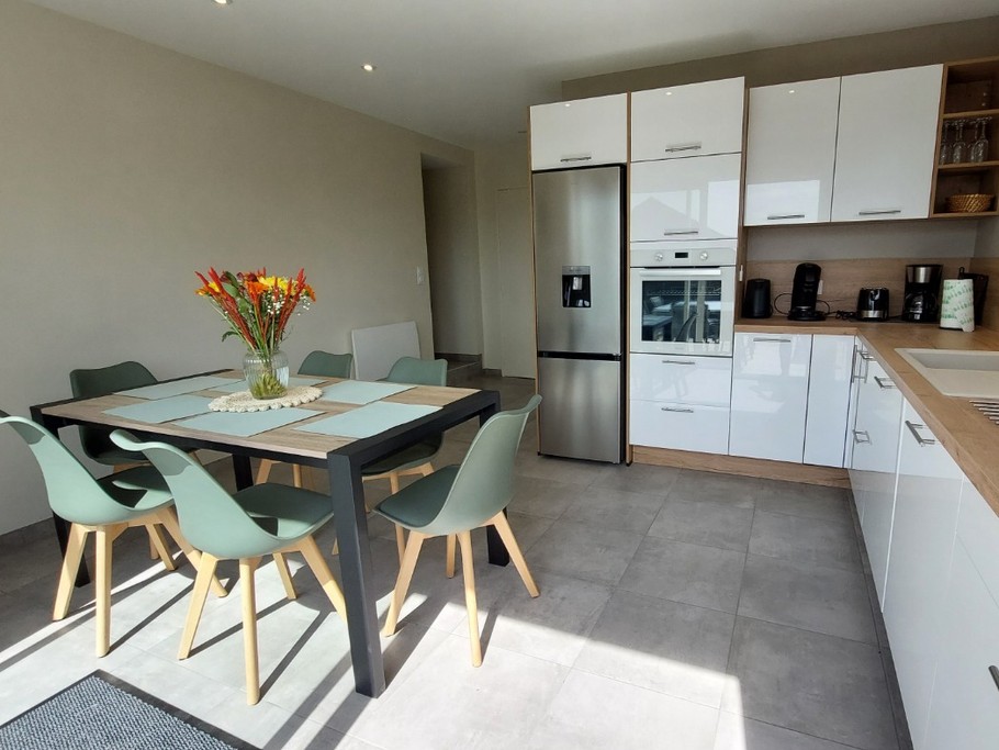 Cuisine équipée et lumineuse avec accès direct à la terrasse, parfaite pour préparer de bons petits plats."