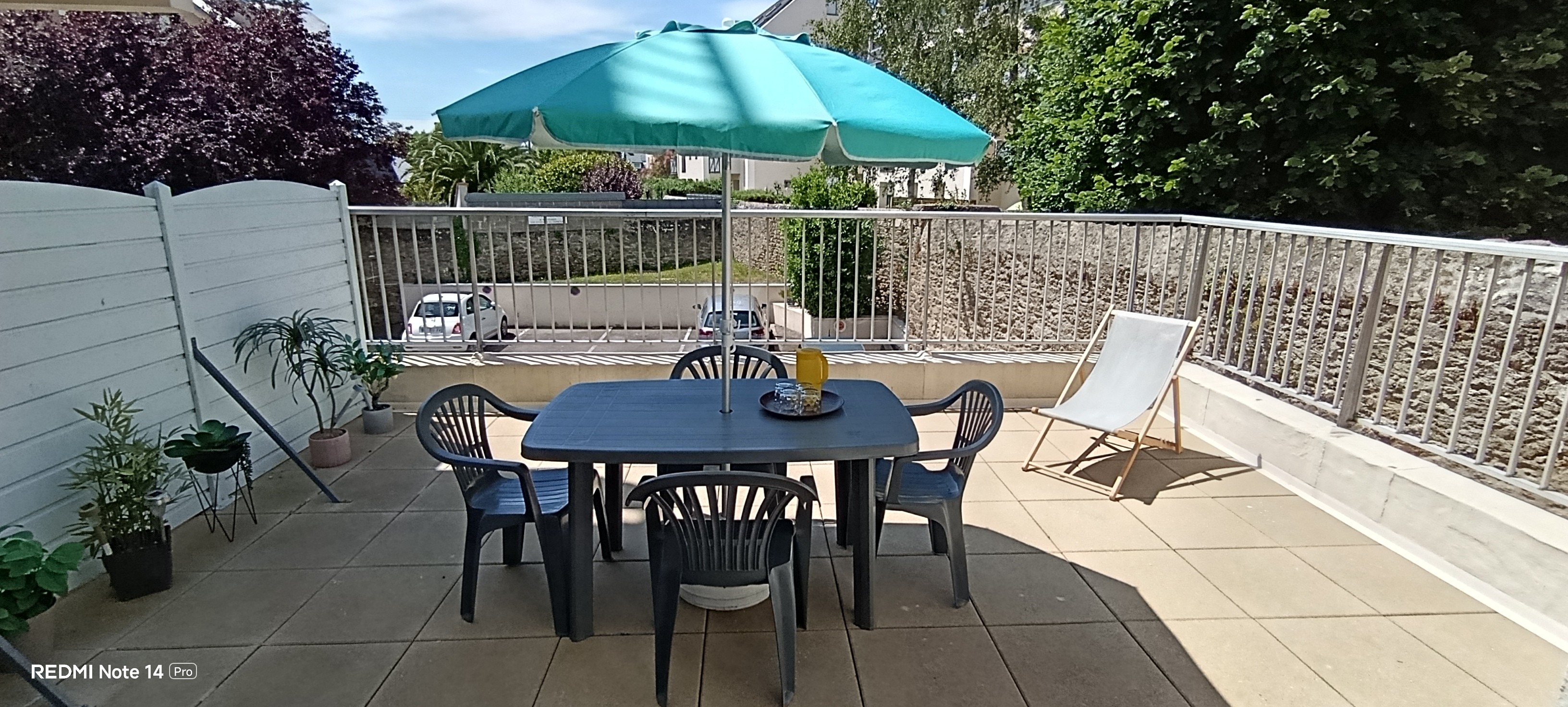 A lovely 25 m² terrace with garden furniture, 1 sun lounger and 1 parasol.  The terrace overlooks lush green surroundings.