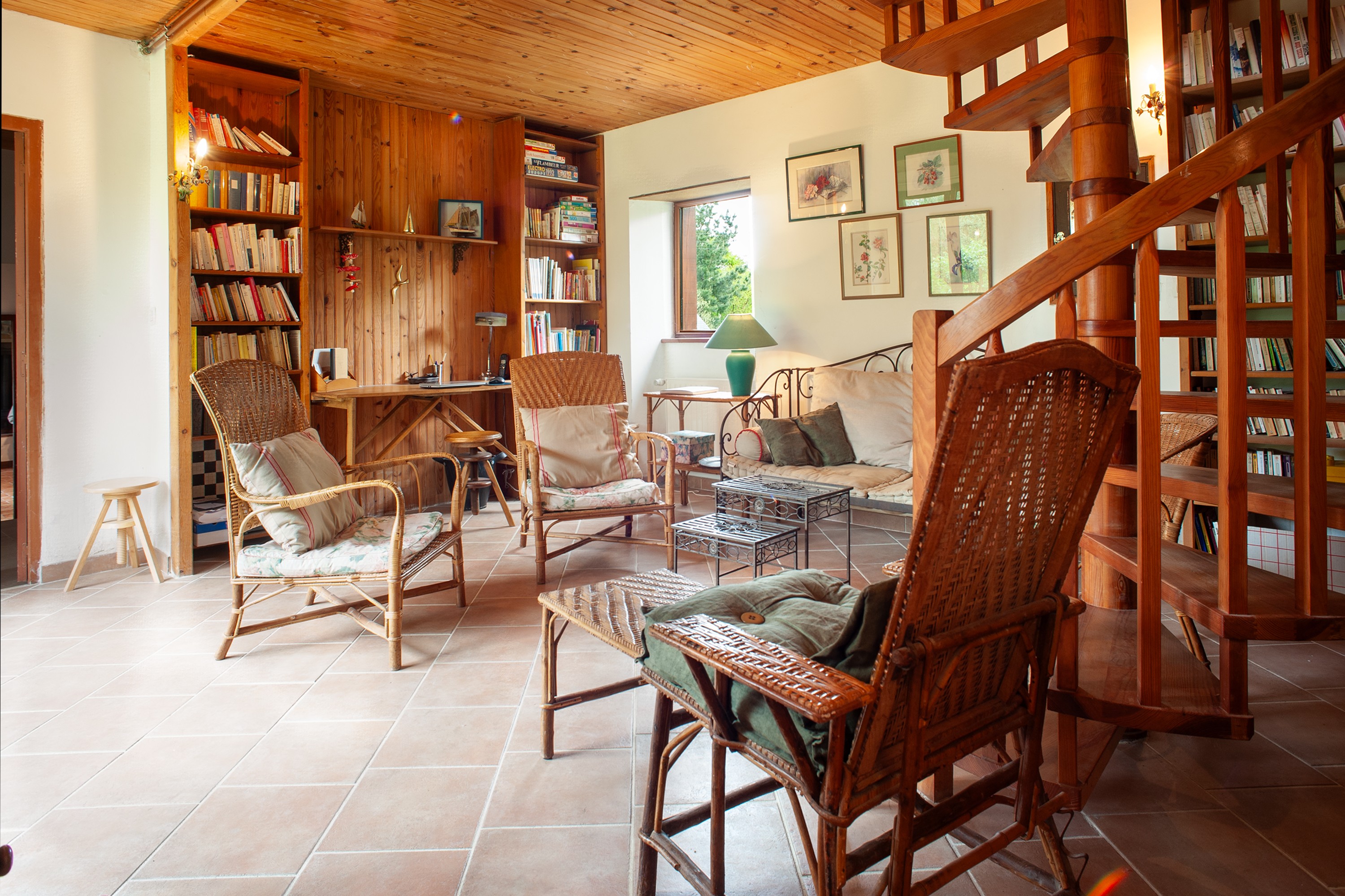 Le salon TV-bibliothèque et son bureau au fond
