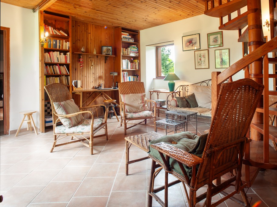 Le salon TV-bibliothèque et son bureau au fond