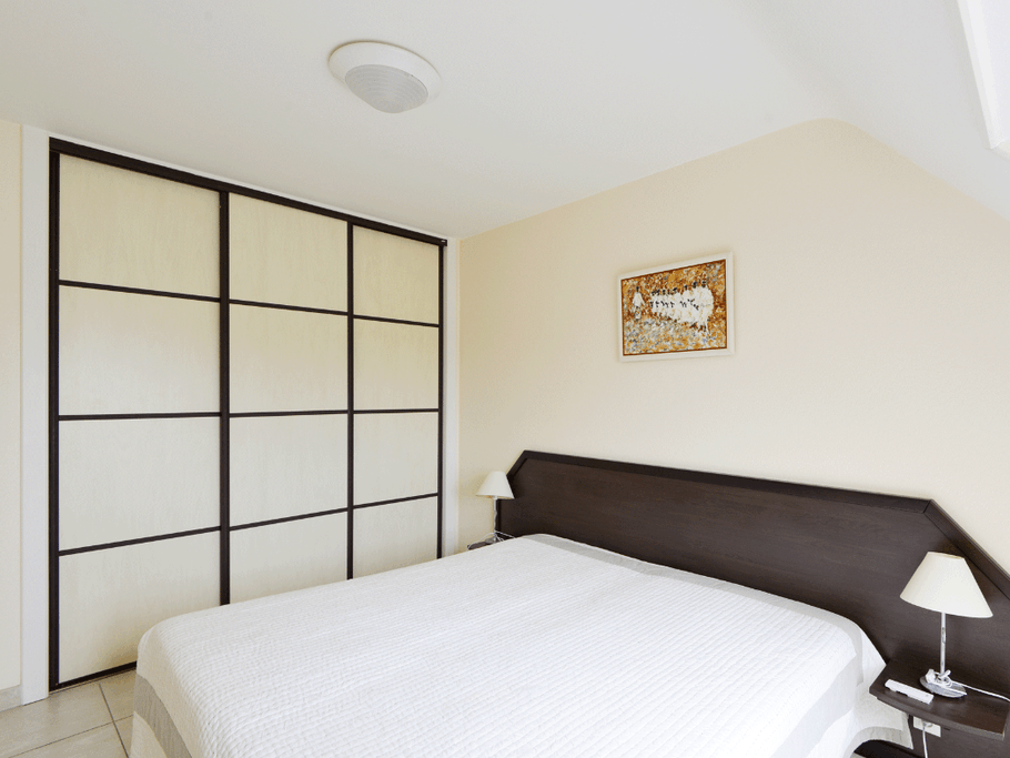 chambre n°1 avec grande armoire intégrée avec penderie et étagères de rangement