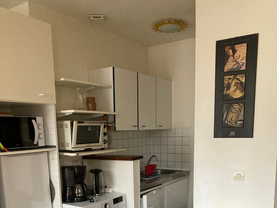 Coin cuisine ( plaques induction, peut fournir, micro-ondes, frigo, petit congélateur, lave linge