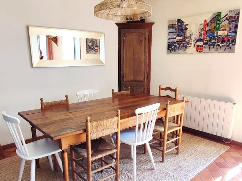 Grand salon chaleureux avec poutres apparentes et cheminée d'apparat.
Crédits photo : Mégane ARNAL