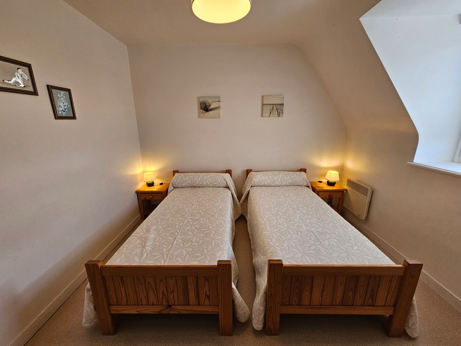 Chambre indépendante pour 2 personnes avec 2 lits 90x190 cm, commode, armoire et chaise.