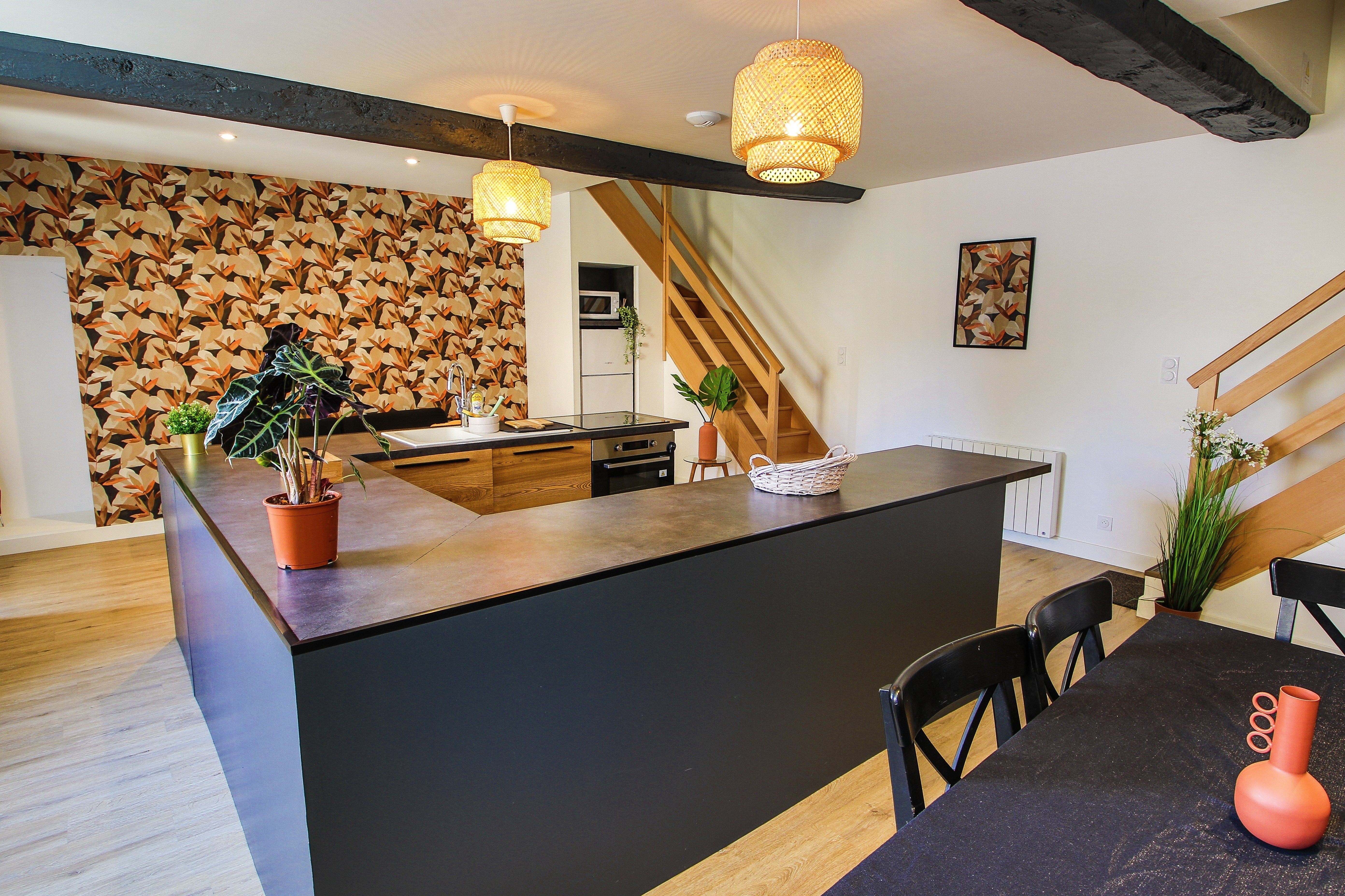 Pièce de vie au rez-de-chaussée avec sa cuisine ouverte, un coin séjour, un coin salon. 2 escaliers de part et d'autres desservent les 2 chambres.
