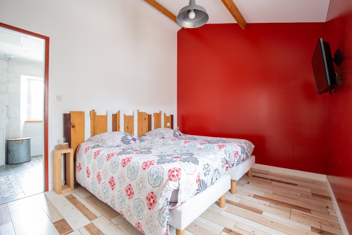 Chambre avec deux lits simples, grand placard et TV.