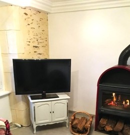 Salon avec poêle à bois pour des soirées conviviales en hiver.