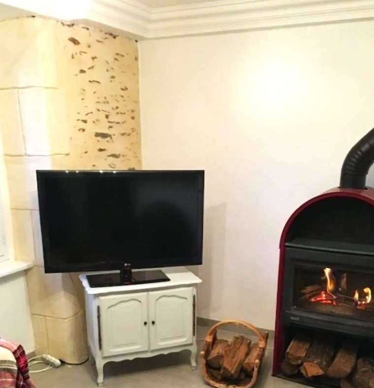 Salon avec poêle à bois pour des soirées conviviales en hiver.