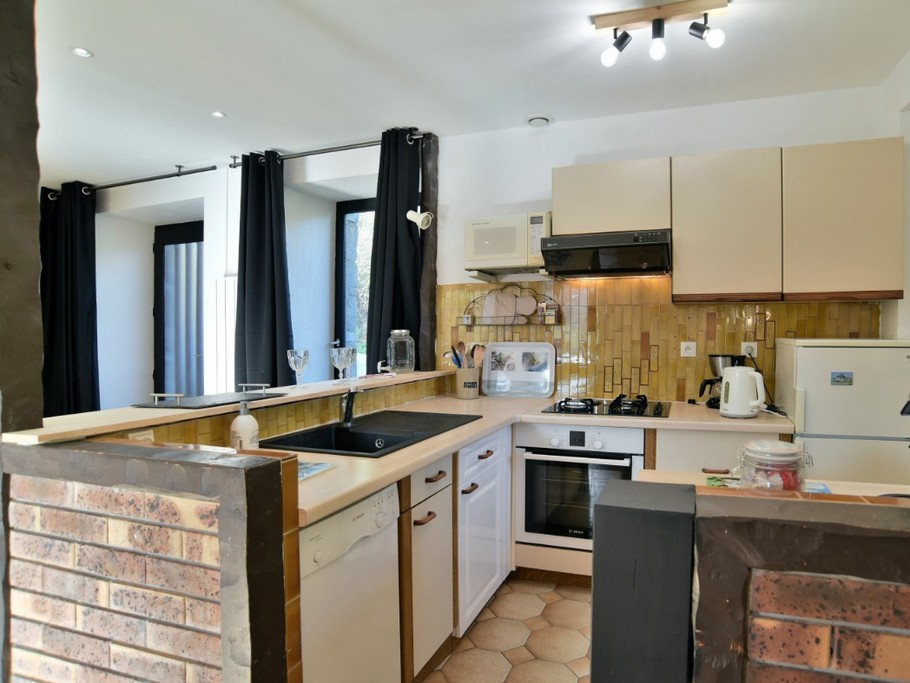 Grande pièce de vie au RDC avec coin cuisine ouverte, toute équipée (lave-vaisselle, four, combiné-congélation, machine à café filtre et expresso, petit électroménager, etc.)