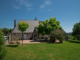 Terrasse du gîte avec barbecue, transats et salon de jardin face à la nature