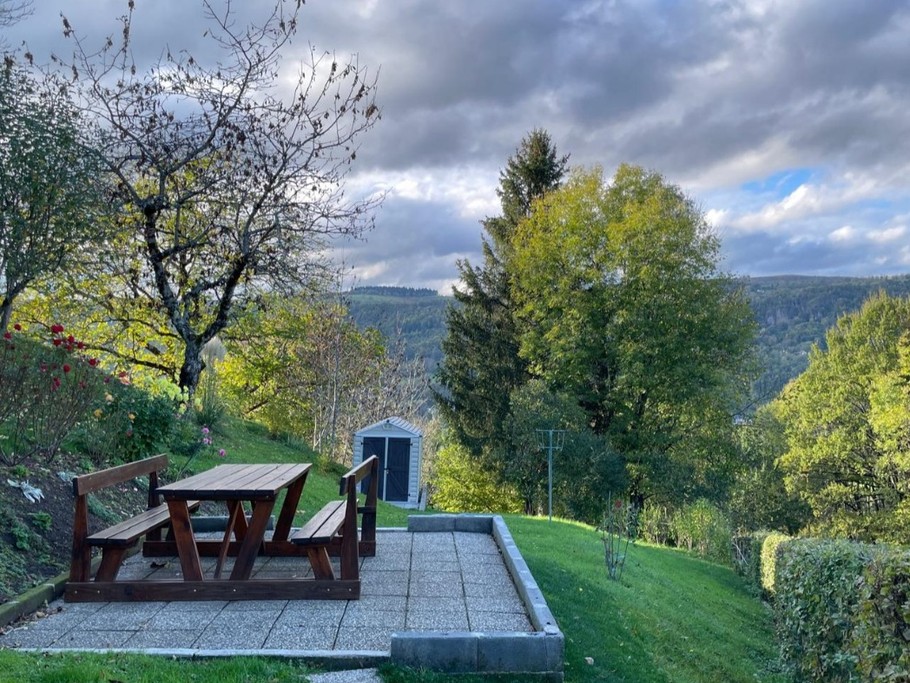 Vue panoramique depuis le jardin sur les montagnes environnantes, offrant calme et sérénité.