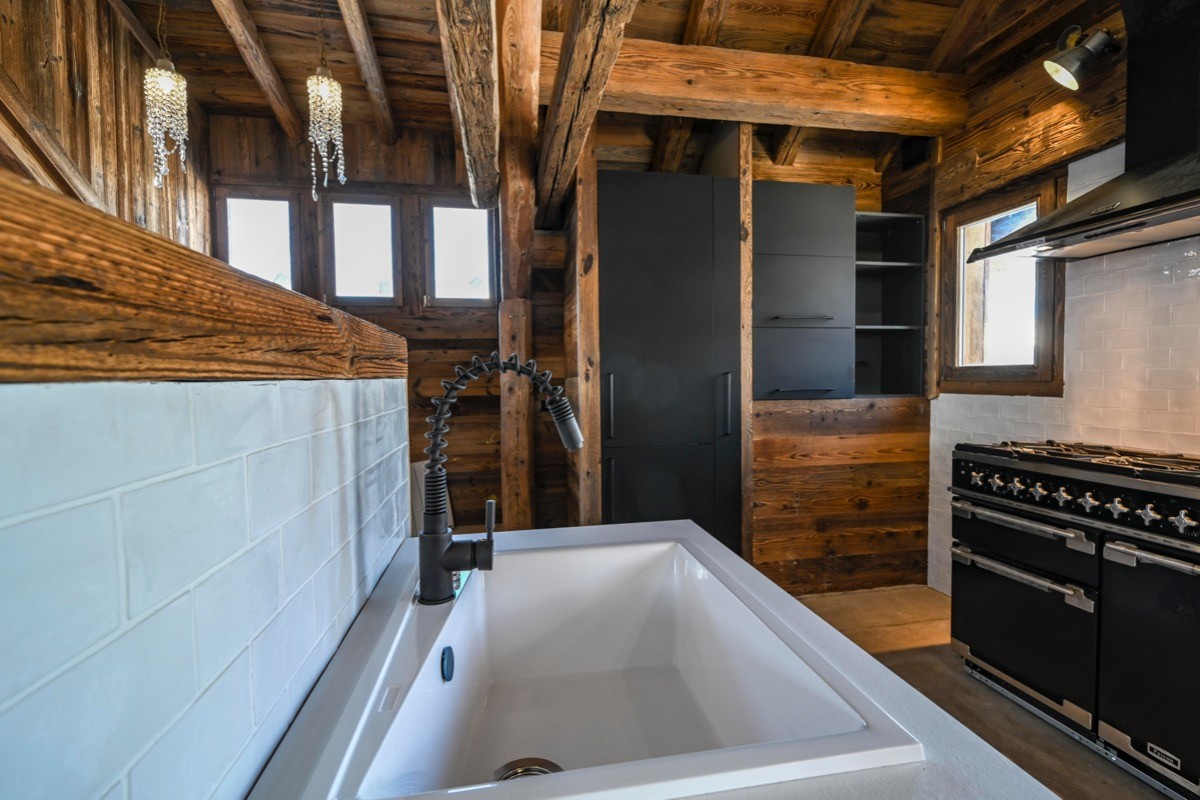 une vue de la cuisine avec son piano de cuisson, réfrigérateur congélateur intégré