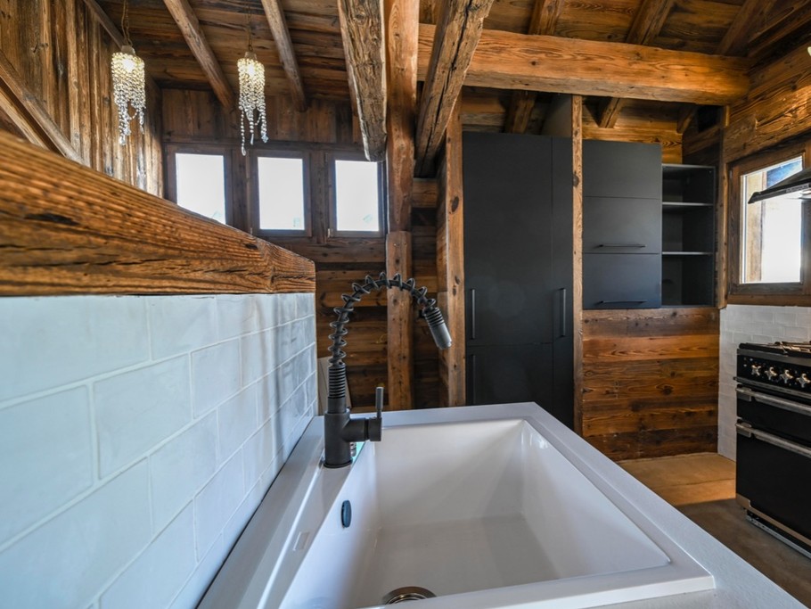 une vue de la cuisine avec son piano de cuisson, réfrigérateur congélateur intégré