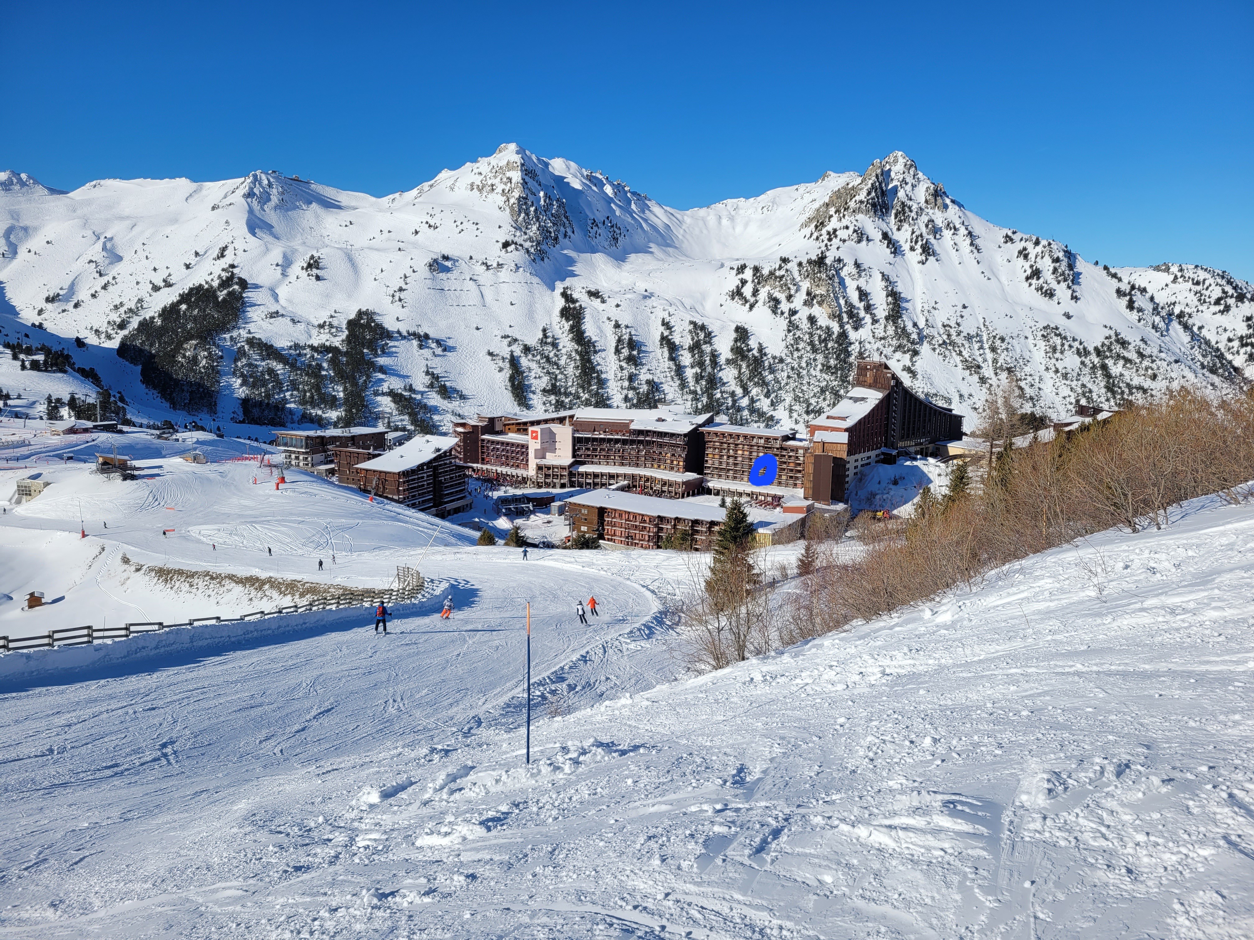 Vue sur Arc 2000 et l'appartement entouré en bleu. Hiver.