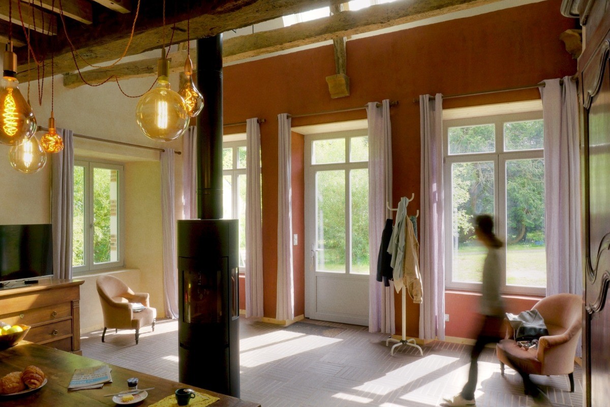 Pièce de vie en rez-de-jardin équipée d'un poêle à bois, avec espace salon, espace séjour et espace cuisine parfaitement équipée. Vaisselle haut de gamme fabriquée en France et électroménager de très bonne qualité.