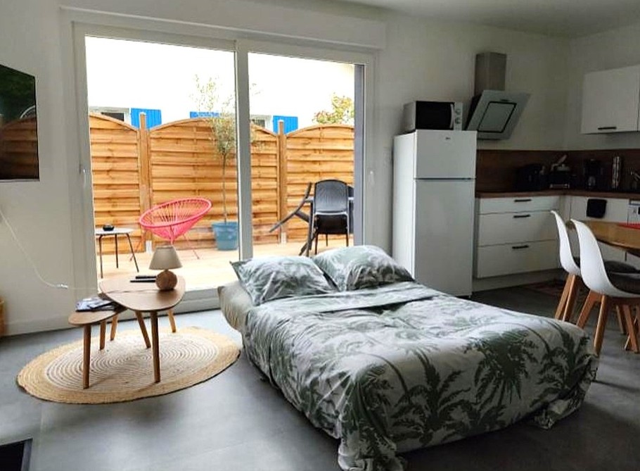 Pièce de vie au rez-de-chaussée avec coin salon avec TV, et coin cuisine et sa table à manger. Canapé convertible pour 2 personnes. Terrasse en bois accessible par un portillon ou par la baie vitrée.